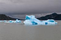 Blau auf Grau  Auch wenn beim Blick zurück Unwetter verheißende Wolkenbänke drohen, liegt im Kontrast der soeben passierten Eisberge zum düsteren Himmel ein größerer visueller Reiz, als wenn sie mit blauem Himmel hätten wetteifern müssen.  Glücklicherweise bleiben die Wolken auch dort, wo sie sind, der Wind weht nur ganz lau und auch von oben bleibt es trocken.