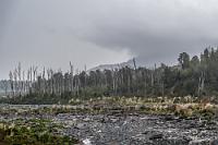 Das Grauen  Nach dem Verlassen der Fähre liegt vor uns mit einer schmalen, staubigen Schotterpiste der erste wirklich abenteuerliche Abschnitt der Carretera Austral. Wenn ich allerdings hinter den beiden führenden Meditationsfahrern bleibe, werden die 56 Kilometer bis zu unserer nächsten Unterkunft in Chaitén voraussichtlich zu einem ganzen Tagestrip. Zudem staubt es derart, dass von der atemberaubenden Landschaft kaum etwas zu sehen ist. Todesmutig überhole ich also die beiden Hindernisse, so dass wir jetzt zügig und staubfrei vorankommen.  Das mit dem Staub erledigt sich dann allerdings nach einiger Zeit ganz von alleine, denn es wird zunehmend trüber, bis schließlich heftiger Regen einsetzt, welcher einigen ohnehin tristen Landschaftsabschnitten eine geradezu apokalytische Atmosphäre verleiht.