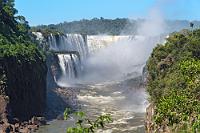 Gigantisch  Wir sind den oberen Weg zurück gewandert und wollen uns am zentralen Restaurant erst einmal mit einem Eis stärken. Dies erfordert aber, dank tiefenentspannter, der Meditativfraktion angehörender Mitarbeiter, mindestens genauso geduldige Kunden. Man kann von Glück reden, dass der Verkaufsraum klimatisiert ist, sonst wäre das Eis von der Entnahme aus der Truhe bis zur vollendeten Bezahlung vermutlich geschmolzen.  Irgendwann haben wir aber unser Magnum-Equivalent und innerlich etwas abgekühlt nehmen wir den "Circuito Inferior", den Unteren Weg in Angriff, auf dem wir alsbald mit einem Ausblick auf das brasilianische Ufer und den beeindruckenden "Garganta del Diablo" (oder portugisisch: Garganta do Diabo) belohnt werden.