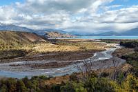 Im Halbschatten  Der östliche Ausläufer des riesigen Sees ist umrundet und wir haben oberhalb der Mündung des Río los Maitenes einen traumhaften Blick über eine vorgelagerte Insel zum gegenüberliegenden Seeufer, wo wir gestern noch nahe des Einschnittes vor den Marmorhöhlen kreuzten. Wir kommen zügig voran, die Straße ist in gutem Zustand und nur ein einziges Mal verzögert eine große Straßenbaustelle (an der fleißig gearbeitet wird!) unser Fortkommen um ca. 20 Minuten.