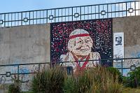 Widmung mit Graffiti  Inzwischen haben wir uns von dem 'Einkaufsbummel' erholt und wir machen noch ein paar Schritte nach draußen, um den Mirador hinter dem Hotel zu erklimmen. Der Treppenaufgang führt entlang eines großen Mosaiks, die "En hommage a los pueblos originarios" darstellt. Noch etwas weiter oben zieht sich ein langgestrecktes, künstlerisch verfremdetes Lama-Mosaik über die Wand, dessen Ausdehnung aber keine Aufnahme erlaubt.