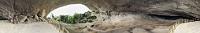 Cueva del Milodón  Die Cueva del Milodón ist in ihrer Größe und Tiefe von ca. 200 m so beeindruckend, dass ich die rufenden und kreischenden Menschenmassen nur beim Videofilmen noch als störend empfand, während Maren beim Fotografieren tapfer um die Figuren herumknipste. Nach und nach kehrten aber immer mehr der Besucher zu den wartenden Reisebussen zurück und die Höhle leerte sich zusehends. Nachdem wir plötzlich und unerwartet die einzigen noch in der Höhle befindlichen Menschen waren, schien mir die Zeit reif für ein 360° Panoramafoto. Innerhalb weniger Minuten drehte ich mich zweimal um die eigene Achse (einmal mit, einmal ohne den kleinen D300 Hilfsblitz) und schaffte es tatsächlich, eine komplett leere Höhle abzulichten. Kaum zwei Minuten später traf der nächste Schwung zweier neuer Reisebusse laut schnatternd in der Höhle ein. Glück gehabt!  Die Höhle stellt eine prähistorische Auswaschung dar, die 1895 von dem deutschen Walfangschiffkapitän Hermann Eberhard entdeckt wurde. Es ist nicht ganz klar, ob bereits Eberhard die Überreste des Riesenfaultieres entdeckte, oder ob der etwas später die Höhle erforschende Wissenschaftler Otto Nordenskjöld diese Ehre für sich beanspruchen kann. Archeologisch gesehen birgt die Cueva del Milodón ebenso wie einige weitere in der Umgebung anzutreffende Höhlen vielerlei Funde und Hinweise auf frühe Bewohner, seien es Tiere wie das bereits vor ca. 10000 Jahren ausgestorbene Mylodon, Höhlenbären, Säbelzahntiger und Riesenfüchse, wie auch auf Jäger, welche der Kultur der Paleoindianer angehörten.  Auf der Besucherplattform hat die Conaf es sich nicht nehmen lassen, eine schönschreckliche Nachbildung des Urbewohners aufstellen zu lassen – in der Originalgröße von gut 3 m Höhe bestens geeignet als Umarmer ganzer Familiengruppen fürs Erinnerungsfoto. Man möge es mir nachsehen, dass der hintere Teil der Höhle nicht optimal ausgeleuchtet ist. Aber abgesehen davon, dass ich die Studioblitzanlage nicht mitgenommen hatte, wäre auch gar nicht genug Zeit gewesen, diese aufzubauen (s.o.). Deswegen reicht der Blick auch nur so weit, wie der kleine Hilfsblitz ausleuchten konnte – sehr viel weiter geht's aber auch nicht... ;-)   360° Freihandpano aus 21 Hochformataufnahmen