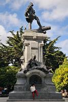 Herr und Knecht  So martialisch präsentiert sich im Zentrum der Plaza de Armas das Denkmal für Ferdinand Magellan, den Entdecker der gleichnamigen Seepassage zwischen dem Festland und Feuerland im Jahre 1520. In typisch kolonialer Manier sind ihm zu Füßen zwei indianische Ureinwohner drapiert. Auf der hier nicht sichtbaren Rückseite läßt ein Patagonier seinen Füß herabbaumeln – ein Glücksbringer für Touristen, denen die Berührung des bronzeglänzenden Fußes eine baldige Wiederkehr verspricht.