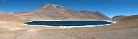Laguna Miñiques  Die kleinere der beiden Lagunen liegt aber immerhin zu Füßen des höheren Berges. Der im Hintergrund sichtbare Miñiques erreicht fast 6000 m Höhe, was man ihm aber kaum ansieht, da die Hochebene mit der Lagune sich bereits auf 4100 m befindet. Die beiden Lagunen Miscanti und Miñiques gehören noch zur Reserva Nacional Los Flamencos, die auch den Salar de Atacama umfaßt.  Obwohl man es in der kargen Landschaft kaum erwartet, leben hier Schakale, Vicuñas, Rebhühner, Flamingos und viele kleine Nagetiere, die den Füchsen als Nahrung dienen, wenn sie nicht gerade wegelagernd Touristen um Kekse anbetteln ;-).