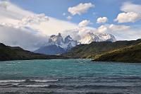 Licht und Schatten  Die maßgeblichen Elemente, die dem schon so oft gesehenen und fotografierten Torres del Paine Massiv ein immer wieder neues und spannendes Aussehen verleihen, sind der Wind, die Wolken und der tageszeitabhängige Sonnenstand. Selten hält sich eine Wetterlage für längere Zeit – der Wind sorgt schon dafür, dass die Landschaft in ständig wechselndes Licht getaucht wird. Bei solchen Anblicken wird aus der normalerweise knapp einstündigen Tour bis zum einzigen Hotel im Nationalpark schnell ein von dauernden Fotostops unterbrochener Abenteuertrip von mindestens zwei Stunden Dauer – nur begrenzt von dem drohenden Restaurantschluß mit nachfolgend knurrendem Magen...  Blick von der Brücke über den Verbindungskanal zwischen dem Lago Pehoe und dem Lago del Torres.
