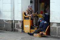 Schuhputzer des Bischofs  Der Erzbischöfliche Palast ist seit 1700 bis heute Sitz des Erzbischofs und nimmt – gegenüber der "Catedral Metropolitana de Quito" gelegen, die gesamte Breite des "Plaza Grande" ein. Als eines der ältesten Gebäude der Stadt und über die Jahrhunderte vielfach erweitert und umgebaut, ist er mit seinen Arkadengängen eines der Zentren des urbanen Lebens. Dies besonders, seitdem Teile des Gebäudes säkularisiert wurden und sich hinter der Arkadenfront Ladenzeilen und Restaurants etabliert haben. Die Arkadenbögen selber wurden fast komplett von Schuhputzern okkupiert, die hier offensichtlich mit einer Lizenz des Bürgermeisteramtes arbeiten, wie die Aufschrift auf den Sitzen und den uniformähnlichen Jacken nahelegt. : quito, plaza grande, plaza de la independencia, palacio arzobispal