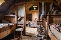 Baðstofa  Den Abschluß auf der Westseite bildet die aus drei getrennten Räumen gebildete "Bettstube", das eigentliche Wohnzimmer des Gehöftes. Im südlichen 'Zimmer' wohnte der Bauer und die Bäuerin, in diesem mittleren Teil lebten die Knechte und Mägde, während im angrenzenden Raum die Kinder untergebracht waren. In der Enge des Zusammenlebens waren strikte Regeln vonnöten, um ein auskömmliches Miteinander sicherzustellen. Um wenigstens ein Minimum an Privatheit zu gewährleisten, besaßen Männer und Frauen nur ihnen zugeteilte Schüsseln und Gefäße. Zudem galt alles, was bei den Männern  unter dem Kopfkissen lag, als so privat und geschützt wie in einem Safe. Weil die Anzahl der Bewohner die der Betten meist überstieg, waren diese in der Regel von zwei Menschen belegt. Die Frauen schliefen unter den Fenstern, weil sie für das Spinnen und Stricken mehr Licht brauchten, während die Männer, denen die gröberen Arbeiten, wie das Kämmen der Wolle und die Seilherstellung oblag, mit weniger Licht auskamen.