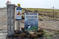 HÆTTA!  Als nächstes Ziel steht Dyrhólaey auf Marens Zettel. Wir wissen nicht so recht, was uns außer 'beeindruckenden Klippen' dort erwartet, biegen aber kurz vor dem südlichsten Punkt des isländischen Festlandes dann doch von der 1 auf die kurze Zufahrtsstraße ab. Das Wetter ist schön, die Sonne scheint und den Sturm bemerken wir erst wieder richtig, als wir beim Aussteigen die Autotüren krampfhaft festhalten müssen. Nachdem wir die ziemlich hohen Küstenklippen über mehrere Serpentinen erklommen haben, parken wir das Auto in Sichtweite des Leuchtturms auf dem kleinen Parkplatz. Da wir während der Öffnungszeiten da sind und auch nicht von den Klippen zu fallen gedenken, begeben wir uns hinter die Absperrung.