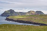 Haltebucht  Die Straße windet sich vom Hügel hinab zum Hals der Stórhöfði Halbinsel, deren Ufer beidseitig von einem schwarzen Strand gesäumt werden. An dem westseitigen Ufer sind zudem in einiger Entfernung rastende Entenschwärme sichtbar. Der Nachmittag ist noch jung, das Wetter hat sich beruhigt, sogar die Sonne sorgt bei dünner Bewölkung für freundliches Licht. Kurz entschlossen biegen wir auf den Strandparkplatz ab, den das einzige parkende Fahrzeug gerade verläßt. Wieder schultern wir unsere Kameras, wechseln noch die Jacken und ich vergesse in dem Hin und Her tatsächlich, das Auto abzuschließen.