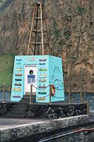 Heimaey Lighthouse  Gegenüber der mächtigen Felswand des Inselausläufers, welcher die Hafeneinfahrt vom offenen Meer abschirmt, bietet dieses hübsch illustrierte kleine Leuchtfeuer ebenfalls ein reizvolles Fotomotiv.