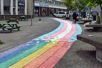 Stadtbild  Wir wissen nicht, ob Ísafjörður auch dem Zeitgeist huldigt, oder ob der gebrochene Regenbogen einfach nur ein bißchen Farbe ins Stadtbild bringen soll. Wir haben zumindest auf der ganzen Reise nicht eine einzige Regenbogenfahne gesichtet! Dafür aber, wie bei den meisten Völkern mit einem ungebrochenen Verhältnis zur Heimat, zahlreiche blaue Landesflaggen mit dem rot-weißen Kreuz.  Wieder beschließen wir den Abend im 'Edinborginn', werden vom Wirt wie alte Bekannte begrüßt und sind nach dem Verzehr von zwei leckeren Burgern samt zwei Halben Bier schon fast wieder bettreif.  Auch der nächste Morgen begrüßt uns bedeckt und mit kühlen 10°C. Immerhin gesünder als in Hamburg, welches vor einer nie dagewesenen Glutwelle mit bis zu 30°C steht, wie Maren beim morgendlichen Telefonat mit ihrer Mutter erfährt... Heute ist der Andrang beim Frühstück größer, wir finden trotzdem noch einen Tisch und dank des sehr aufmerksamen Personals wird auch immer sofort alles aufgefüllt. Gut gesättigt brechen wir zu einer langen Tagesetappe nach Patreksfjörður auf. Den ersten Teil der Fahrt kennen wir schon, denn es ist die gleiche Strecke wie gestern, durch den langen Tunnel und über den Pass bis zum Önundarfjörður.