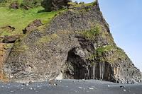 Top Location  Nur einen kurzen Weg vom Parkplatz entfernt erreichen wir den Küstenstreifen, der sich am Fuße des Berges Reynisfjall erstreckt. Schon bevor man auf den eigentlichen Strand biegt, türmen sich mehrere Meter hohe, massive Ansammlungen von Basaltkolumnen gleich neben einer flachen Höhlung im Berg. Bemerkenswert ist auch die freiliegende Felswand, die nicht aus glattem Stein besteht, sondern aus Bündeln unendlich vieler verwobener, kleiner Basaltstelen. Damit ist man schon mal vorbereitet auf das, was sich hinter Kurve fortsetzt.