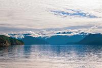 Jervis Inlet  Trotz der kleinen Exkursion sind wir um 9 Uhr rechtzeitig am zweiten Fähranleger dieses Morgens. Auch hier geht das Boarden Dank der bereits gebuchten und bezahlten Voucher problemlos vonstatten und wenig später schippern wir auf der gut einstündigen Überfahrt durch eine abwechslungsreiche Inselwelt. Über unserem Ziel hängen zwar noch tiefe Wolken, über uns reißt die Wolkendecke aber schon ab und zu auf und betupft die grünen Inseln mit vereinzelten Sonnenstrahlen.