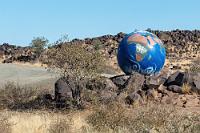 Der Globus hat 'nen Haken!  Weitere 160 km liegen heute noch vor uns. Wir biegen in Keetmanshoop von der B1 auf die ebenfalls asphaltierte B4, kürzen unseren Weg zum Gondwana Nature Park dann aber über die Sandpiste der C12 ab, die uns an einem weiteren Stausee, dem "Naute Reservoir", vorbeiführt. Der Abzweig zum "Naute Dam Rest Camp" wird unübersehbar durch diesen bemerkenswerten Globus markiert.