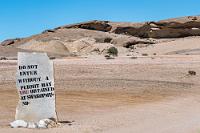 Do not enter!  Eine Zuwegung lädt zur Erkundung der höhlenartigen Öffnung des Felsens ein. Es steht aber bereits ein Jeep dort und mehrere Leute laufen herum, von denen wir uns nicht unbedingt nach einem ungelösten Ticket befragen lassen wollen. Es fehlte noch, dass wir uns strafbar machen...