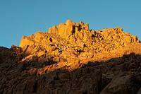 Lichtspiele  Bald erglühen nur noch die Bergspitzen im Licht der schon fast untergegangenen Sonne. Es ist Zeit für's Abendessen und wir gehen zum Restaurant, in dem schon für uns der Tisch liebevoll gedeckt ist. Wir sind die einzigen Gäste und nach einer leckeren Kürbissuppe wird uns von der aufmerksamen Kellnerin ein saftiges Oryxsteak serviert.  Ein Glas Wein beschließt den Abend und zurück im Bungalow fallen wir alsbald todmüde ins Bett.