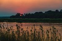 Romantic dinner background  Der Weg zum Abendessen im zentralen Rundrestaurant führt über einen Holzbohlensteg, auf dem wir noch einen Moment verweilen, um den malerischen Sonnenuntergang zu genießen.  Wie immer ist das Essen reichlich, sehr schmackhaft und ausgesprochen fleischlastig. Der Genuß unterschiedlich zubereiteter Wildarten wie Oryx, Springbock, Kudu und Elen ist eine interessante Erfahrung, die wieder mal beweist, dass Namibia nicht unbedingt das optimale Urlaubsziel für eingefleischte Veganer ist ;-).