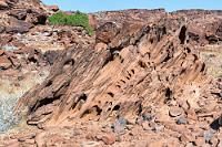 Schmelzfels  Wir sind bereits gegen Mittag hier angekommen und noch unternehmungslustig. Das am Campeingang aufgebaute "Damara Living Museum" bietet touristisch aufbereitet einen Einblick ins traditionelle Dorfleben der Damara inkl. Stammestanz barbusiger Mädchen und interessiert uns deshalb nicht weiter.  Wir brechen lieber zu den nicht weit entfernten Fundstellen prähistorischer Felsritzungen auf – den ältesten Funden dieser Art in ganz Afrika.