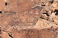 Trittspuren  Schon das Einparken auf dem Parkplatz beim Denkmal erfolgt überwacht, kaum ausgestiegen werden Kennzeichen, Personalien etc. notiert, erst dann dürfen wir das Empfangsgebäude mit Ticketverkauf und Souveniershop betreten. Außer zwei weiteren Gästen sind wir alleine. Wir erwerben zwei Tickets für 500 NAD und durchlaufen erneut die umfangreiche Anmeldeprozedur.  Die Felszeichnungen dürfen nur mit Guide besucht werden, dessen baldiges Erscheinen uns in Aussicht gestellt wird.