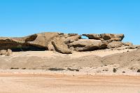 Vogelfeder?  Die Weiterfahrt auf der C14 führt über eine endlos scheinende Strecke durch nichts als schwarz-beige Wüstenei. Erst nach knapp hundert Kilometern erhebt sich links der Straße eine auffällige Granitformation, der "Vogelfederberg". Woher der Name rührt und welches Merkmal möglicherweise an eine 'Vogelfeder' erinnert, läßt sich zumindest vom Rastplatz an der Straße aus nicht nachvollziehen. Immerhin gibt es hier ein – benutzbares! – Toilettenhäuschen.