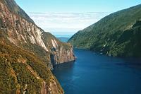 Another sunny Milford view (w/o polfilter)  Leider kann man sich die spiegelungsfreien Schußwinkel in einem kleinen Flieger nicht aussuchen – man muß dann schon die Motive nehmen, wie sie kommen. Dafür ist der Himmel in Echtfarben und nicht in Schwarzblau...  Das Bild zeigt den Milford Sound kurz vor der Öffnung in die Tasman Sea (im Hintergrund) : southern alps, südalpen, queenstown, fiordland, milford sound