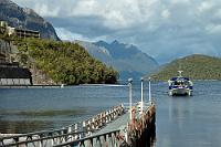 Auf halbem Weg zum Doubtful Sound  Jeder, der den Doubtful Sound besuchen will, muß zuvor eine Bootsfahrt über den Lake Manapouri machen, bevor er im Reisebus über die Southern Alps an die Westküste zum Fjord gekarrt wird. Der Zubringer-Katamaran aus Pearl Harbour legt bei der  Manapouri Power Station  an, dem größten Wasserkraftwerk Neuseelands. Links sieht man einen Teil des Einlaßbereiches – abgesperrt durch Schwimmer – hinter dem 170 m lange Fallrohre das Wasser des Sees in das Kraftwerk leiten. Fast obligatorisch ist für jeden Touristen der im Preis eingeschlossene Besuch der Power Station tief unten im Berg – eine sehr interessante Erfahrung, die man sich nicht entgehen lassen sollte.  P.S. Die Stromleitungen gehören ins Bild, denn irgendwo muß der erzeugte Strom ja hin...