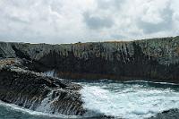 Black Rocks  In der Bay of Islands treten an vielen Stellen einzelne Felsen und Felswälle zu Tage, die sich in ihrer schroffen dunklen Färbung von den anderen Formationen der Inseln abheben. Die erstarrte Lava soll wohl in dieser Form weltweit sehr selten sein und außer an der Bay nur noch ein weiteres Mal vorkommen. Worin sich die 'Black Rocks' nun aber explizit von anderen vulkanischen Artefakten unterscheiden, war nicht herauszukriegen ;o). Sehenswert in den oft hunderte Meter langen Wällen sind die höhlenartigen Auswaschungen und Durchbrüche, die wie ein löchriger Palisadenzaun den Durchblick zur anderen Seite gestatten, sowie die Verfärbungen durch Wasser und Wetter mit einer deutlich abgesetzten oberen Flutmarke.   Das obige Bild geht zurück auf ein 'Negativ', welches ich unter normalen Umständen keines Blickes gewürdigt hätte. Viel zu starke Kontraste mit rettungslos ausgefressenem Himmel und total abgesoffenen Schatten. Glücklicherweise war es in RAW aufgenommen! Dieses  Bild    zeigt das Original RAW, so wie es aus dem 'Nikon Capture'-Entwickler kam. Nicht sehr vielversprechend! Das Potential des RAW-Formats erschließt sich erst, wenn man mit der Belichtungskorrektur spielt. Aus dem Original wurden in 'Capture' zwei Belichtungsvarianten gewonnen (- 1.17 LW / + 1.50 LW) und gemeinsam nach PS überführt. Hier habe ich sie überlagert und mittels Ebenenmaske und Farbselektion manuell ineinander überführt. Ohne großen Aufwand (und ohne DRI und Photomatix) ist so ein Bild erheblich größeren Dynamikumfangs entstanden, als es das ursprüngliche RAW vermuten ließ.    2005 waren die Digitalsensoren noch erheblich leistungsschwächer, was sich meist durch einen sehr begrenzten Dynamikbereich bemerkbar machte. Der zweite Teil der Bildunterschrift in der FC war daher als eine kleine Gebrauchsanleitung zu verstehen, wie man die Grenzen der Technik zumindest etwas durchlässiger gestalten konnte. : northland, bay of islands, te rawhiti inlet, pahia, russell, haruru, waitangi, waitangi river,black rocks