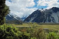 Leider ein wenig fotoscheu...  ...präsentierte sich Mt. Aoraki während unseres Aufenthaltes 2004/05 in seiner Umgebung. Nie bekamen wir ihn mit völlig freier Spitze zu sehen. Dafür aber, dass man uns drei Tage zuvor bei unserer Ankunft in Christchurch mit der Aussage schockte, die Wochen zuvor hätten den schlechtesten Sommer seit 60 Jahren repräsentiert, waren wir hiermit schon mehr als zufrieden.  Zumal die nächsten vier Wochen mit nur ca. 3-4 Regentagen alle unsere Wettererwartungen übertrafen.  Blick von oberhalb des Örtchens Mt. Cook in das Hooker Valley – mit dem halbverhüllten Namensgeber im Hintergrund. : mount cook,hooker valley,aoraki,