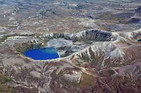 Vulkanischer Surrealismus  Bis vor dem letzten Ausbruch des Ruapehu lebten noch (eingeführte!) Forellen in den beiden Tama Lakes. Auch schwimmen konnte man in dem klaren Wasser.  Seither ist das Wasser jedoch durch mineralische Einträge vergiftet und zeigt eine unwirkliche blaue Farbe. Der am rechten Bildrand gerade noch angeschnittene Upper Tama Lake ist sogar noch ein wenig dunkler gefärbt als der hier zu sehende Lower Tama Lake. Aus dem Flugzeug wirkt der Erdboden zudem seltsam unnatürlich und man kann sich seine tatsächliche Beschaffenheit anhand des Fotos kaum vorstellen. : tongariro national park, ketetahi, ketetahi hot springs, ngauruhoe, ruapehu, emerald, emerald lakes, north crater, red crater, tongariro crossing, tama lakes, lower tama lake