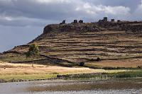 Chullpas de Sillustani  Einen touristischen Frevel der besonderen Art haben wir uns geleistet, indem wir die Grabtürme von Silliustani einfach links (genaugenommen eher 'rechts') liegen ließen. Die "Chullpas" genannten Türme sind Zeugnisse von Begräbnisriten verschiedener Völker, die zwischen 400 und 1500 n.Chr. nacheinander hier lebten und sich in ihren Kulturen beeinflußten. Unsere 'Abkürzung' brachte uns tatsächlich nach Puno und damit auch vorbei am Lago Umayo, in dem auf einer Halbinsel der Hügel mit den Grabtürmen steht. Wir kommen aber nicht weiter als bis zu einem großen Touristenparkplatz, auf dem obligatorisch alle Fahrzeuge geparkt werden müssen – bis zum Hügel sind es gut und gerne noch 2 km Fußweg mit Kraxeln. Das wollen und können wir uns heute abend nach der langen Autofahrt nicht mehr antun. Das Hotel ist noch 50 km entfernt und wir sind einfach nur noch 'knille'. Schweren Herzens belassen wir es bei einem Foto mit dem Tele, denn morgen sind wir schon mit einer Titicacasee-Tour verplant und übermorgen geht's schon weiter. Zeit müßte man haben!
