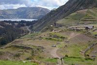 Complejo Arqueológico de Sóndor  Durch einen Taleinschnitt hat man von der Spitze des Hügels einen schönen Blick hinüber zur Lagune von Pacucha und auf den Gebäudekomplex am Fuße des Hügels, in dem immer noch Ausgrabungs- und Rekonstruktionsarbeiten im Gange sind. Aktuell wurden gerade die Steinhäuser mit neuen Binsendächern gedeckt.