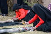 Knochenarbeit  Beeindruckend die Geschwindigkeit und Fingerfertigkeit, mit der die Frauen in ihrer Tracht den am Boden liegenden Webrahmen bearbeiten. Sicherlich ist klar, dass ein Großteil der von den Einheimischen geschaffenen textilen Wunderwerke für den Tourismusmarkt bestimmt ist. Nicht umsonst ist 'unser' Innenhof an den Innenmauern mit voll belegten und behängten Verkaufsständen versehen, an denen nach der Präsentation des Handwerks und der Aufführung eines traditionellen Gruppentanzes der eigentliche Sinn der Veranstaltung seinen kommerziellen Höhepunkt erreicht. Es wird aber auch deutlich, in wie starkem Maße sich die Menschen mit ihrer Tradition identifizieren und in wie großem Umfang sich der Status des Einzelnen in der 1400 Köpfe umfassenden Einwohnerschaft Taquiles noch immer in den Nuancen der Kleidungsmerkmale manifestiert.