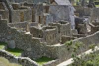 Machu Picchu #26  Der 11 Meter durchmessende Sonnentempel "Sumturhuasi" stellt das Zentrum des Palastviertels dar und ist aus mit höchster Genauigkeit bearbeiteten Steinblöcken errichtet. Die Ausrichtung des nach Süden gerichteten trapezförmigen Fensters stellt sicher, dass die Sonne genau zum Sommerbeginn in eine Nische des mittig im Tempel stehenden Felsentisches strahlt. Links neben dem Tempel steht der Palast der Prinzessin Ñuesta, umgeben von den Wohnungen der Bediensteten.