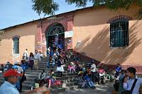 Mercado de Comida Típica  Der Markt, den wir nach dem Durchschreiten des Triumphbogens der '28 de Julio' erreichen, residiert in einem ausgedehnten, aber eher düsteren und flachen Gebäude. Da draußen die Sonne scheint, bevölkern viele Einheimische die Treppe und nutzen ihre Zeit offensichtlich auch zur Pflege sozialer Kontakte.