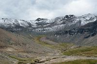 Puderzucker  Knapp 4700 m reichen, nur 15 Breitengrade vom Äquator entfernt, bereits für zarte Schneespuren, die sich wie Puderzucker über die dunklen Hänge verteilen.  Im Vordergrund – mit einem winzig kleinen Fahrzeug – die Straße, die sich noch immer weiter hochwindet.