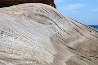 La Ola  Die Seeseite des kleinen Montaña Amarilla, eines Eruptionshügels  der entstand, als Meerwasser in explosiven Kontakt mit einer Magmakammer trat, besteht aus grauen und erdfarbenen Kalkmaterialien, deren Oberfläche im Laufe der letzten Eiszeit abgeschmirgelt und zu einer fantastischen Wellen- und Dünenlandschaft geformt wurde.