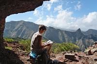Schattenspender  Während die Sonne ein paar hundert Meter nebenan und ebensoviel tiefer kaum den Grund der Masca-Schlucht erreicht, brät sie uns auf dem Bergrücken kräftig auf den Kopf. Glücklicherweise hat die Natur vorgesorgt und aus dem karstigen Tenogestein entlang des Weges ein paar kuschelige Höhlen herausgewittert, in deren Schutz man erst mal den Durst löschen und den Baedeker zu Rate ziehen kann.