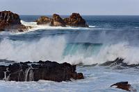 Sonnenflecken  Die vorherrschenden westlichen Atlantikwinde sorgen für einen ständigen Ansturm einer wütenden Brandung an den vulkanischen Klippen der Küste.  Dabei kommen die wehenden Gischtfahnen beim Licht- und Schattenspiel des teilbewölktem Himmels besonders reizvoll zur Geltung.